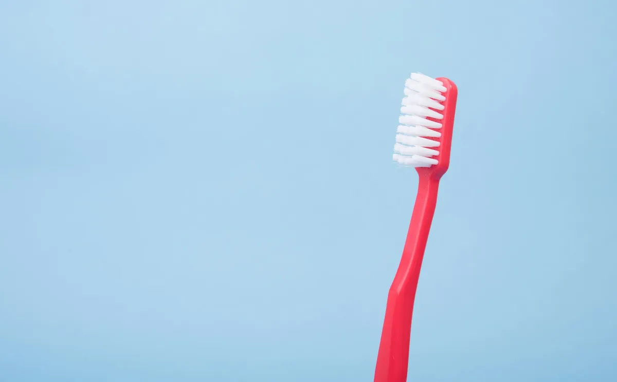 Photo of a red toothbrush on a blue background